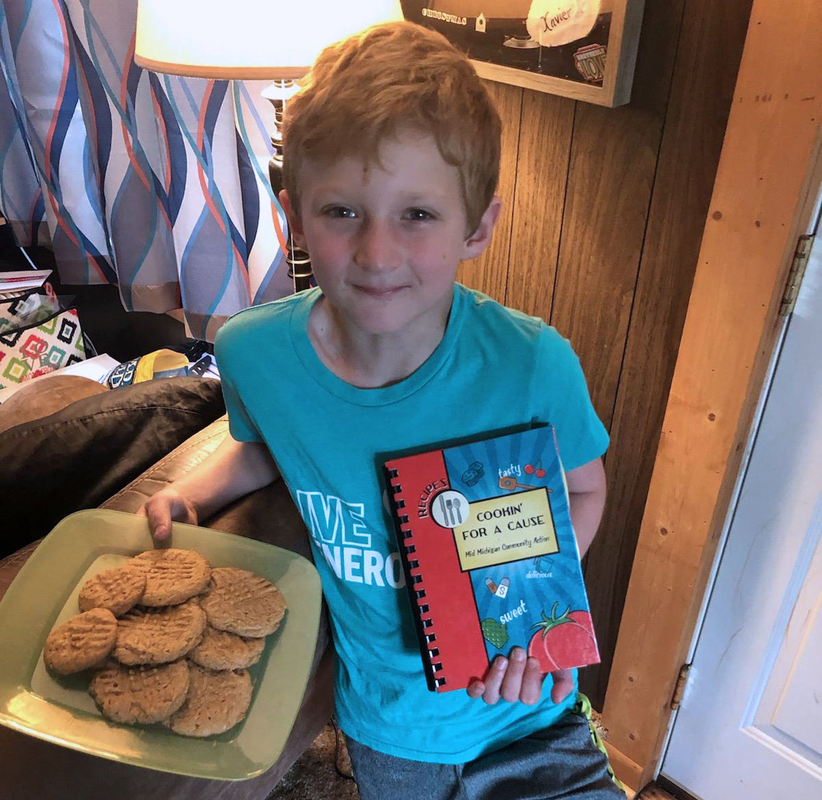 Community Spotlight: Cameron, one of our volunteers, with his cookbook from the volunteer appreciation picnic